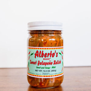 A jar of sweet jalapenos relish on top of a table.
