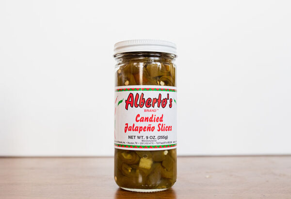 A jar of condided jalapeno slices on top of a table.