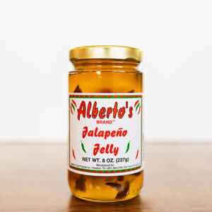 A jar of jalapeno jelly on top of a table.