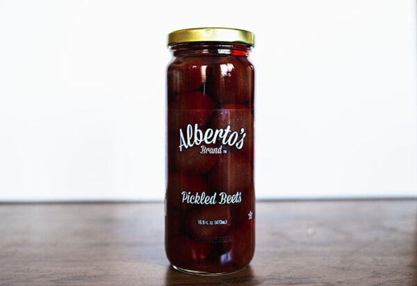 A jar of pickled beets on top of a table.