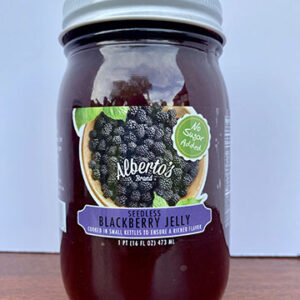 A jar of blackberry jelly on top of a table.