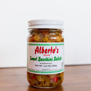 A jar of sweet zucchini relish on top of a table.