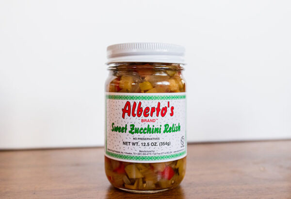A jar of sweet zucchini relish on top of a table.